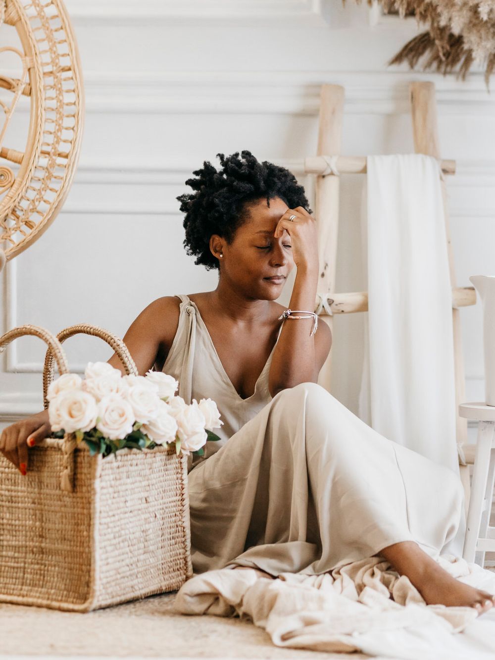 A relaxed moment showing laughter while sitting on the floor with a woven basket of white flowers.
