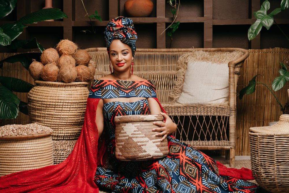 Traditional clothing fashion photoshoot with woven baskets and red fabric in a bohemian setting.