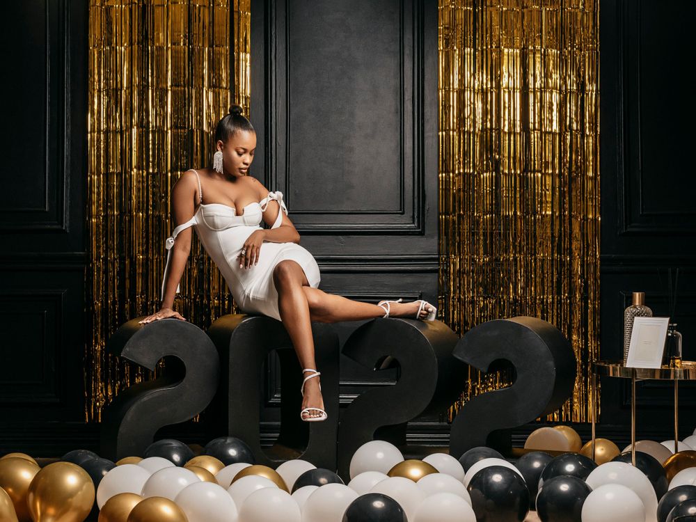 Glamorous New Year celebration setup with 2022 numbers, gold and silver balloons against metallic backdrop.