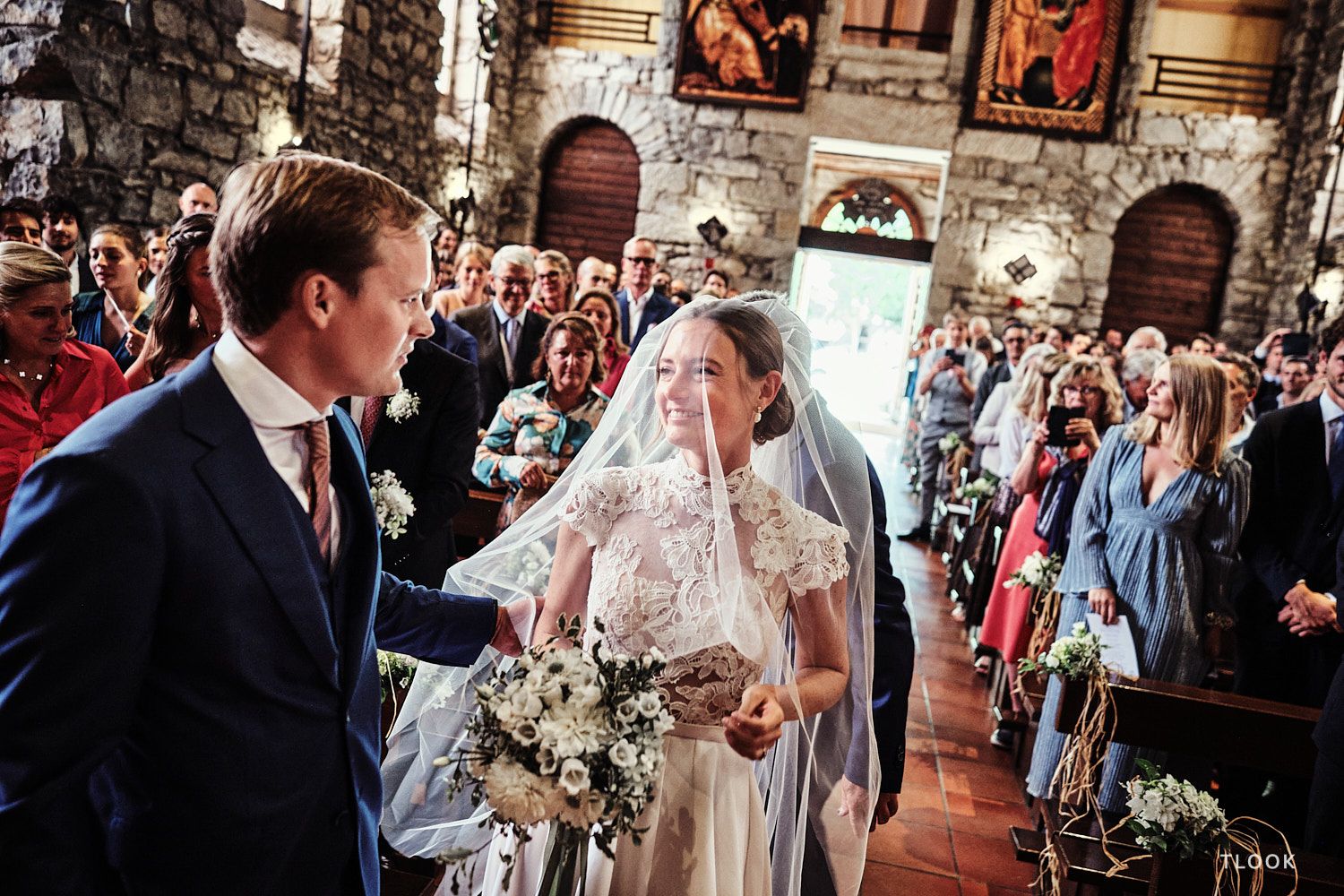 TLOOK photographe de mariage de style documentaire, à la cérémonie religieuse le marié enlève le voile de la mariée