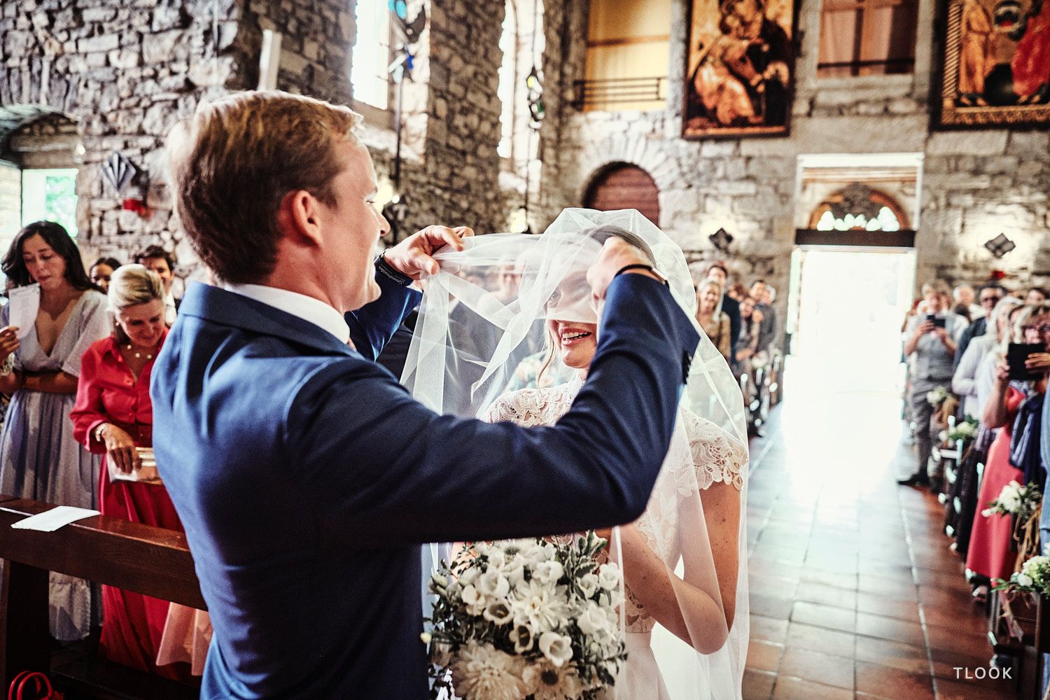 TLOOK photographe de mariage de style documentaire, à la cérémonie religieuse le marié enlève le voile de la mariée