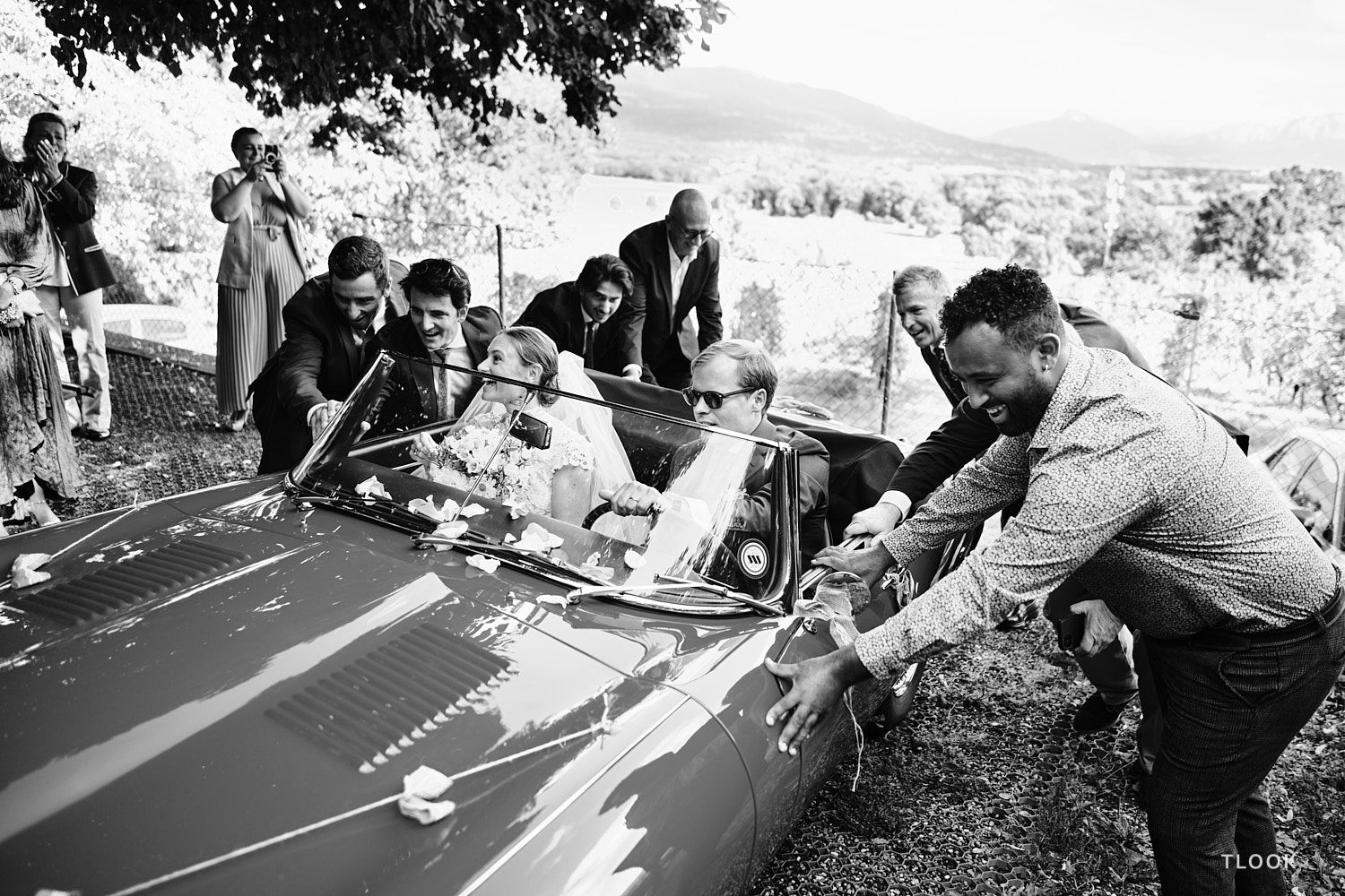 TLOOK photographe de mariage de style documentaire, fin de la cérémonie religieuse les invités poussent la voiture