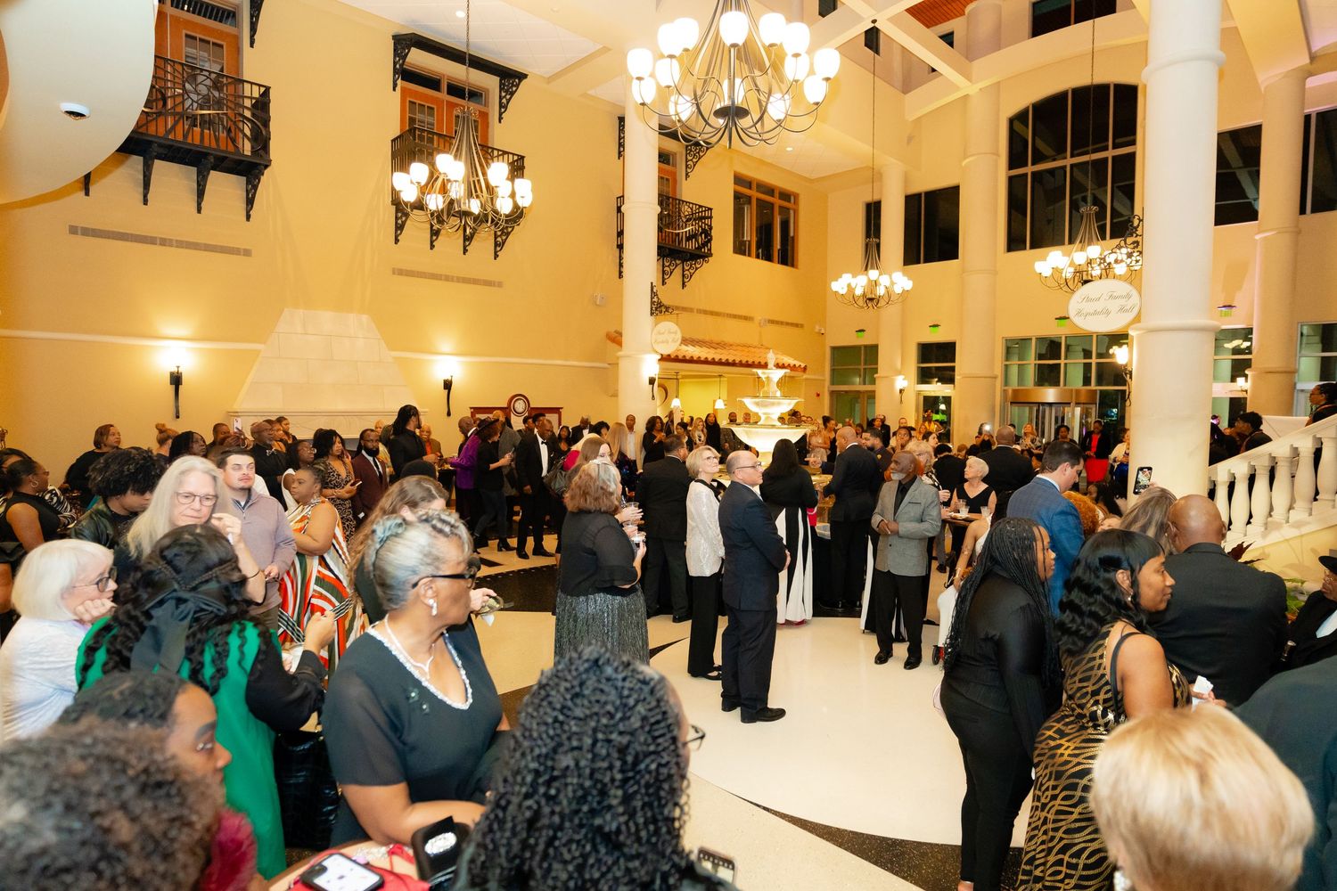 Elegant evening event in grand ballroom with chandeliers and formal attendees.