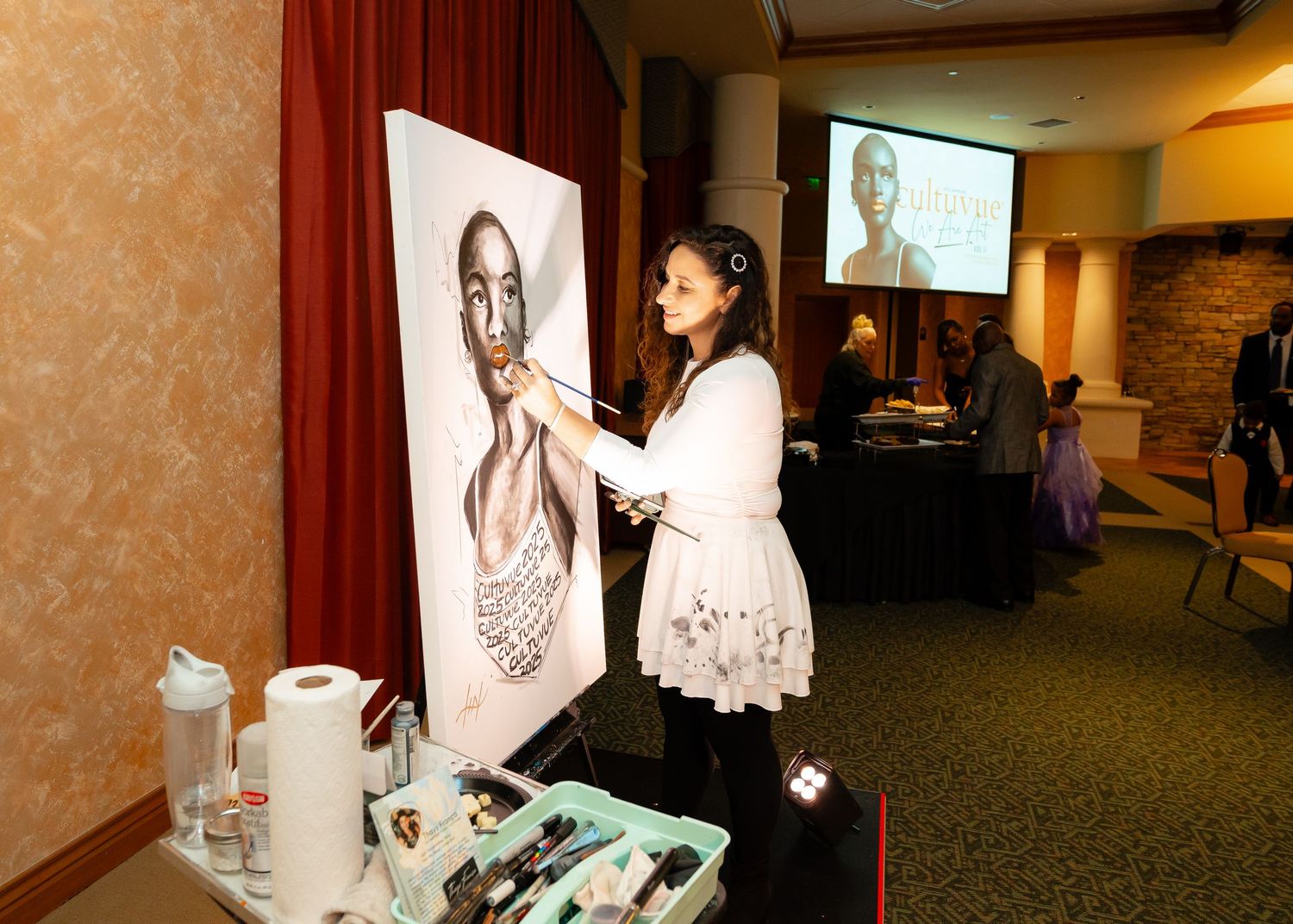 Artist working on a detailed portrait painting during a live demonstration.