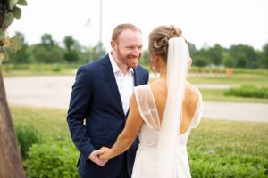 Joyful first look moment between couple in outdoor garden setting.
