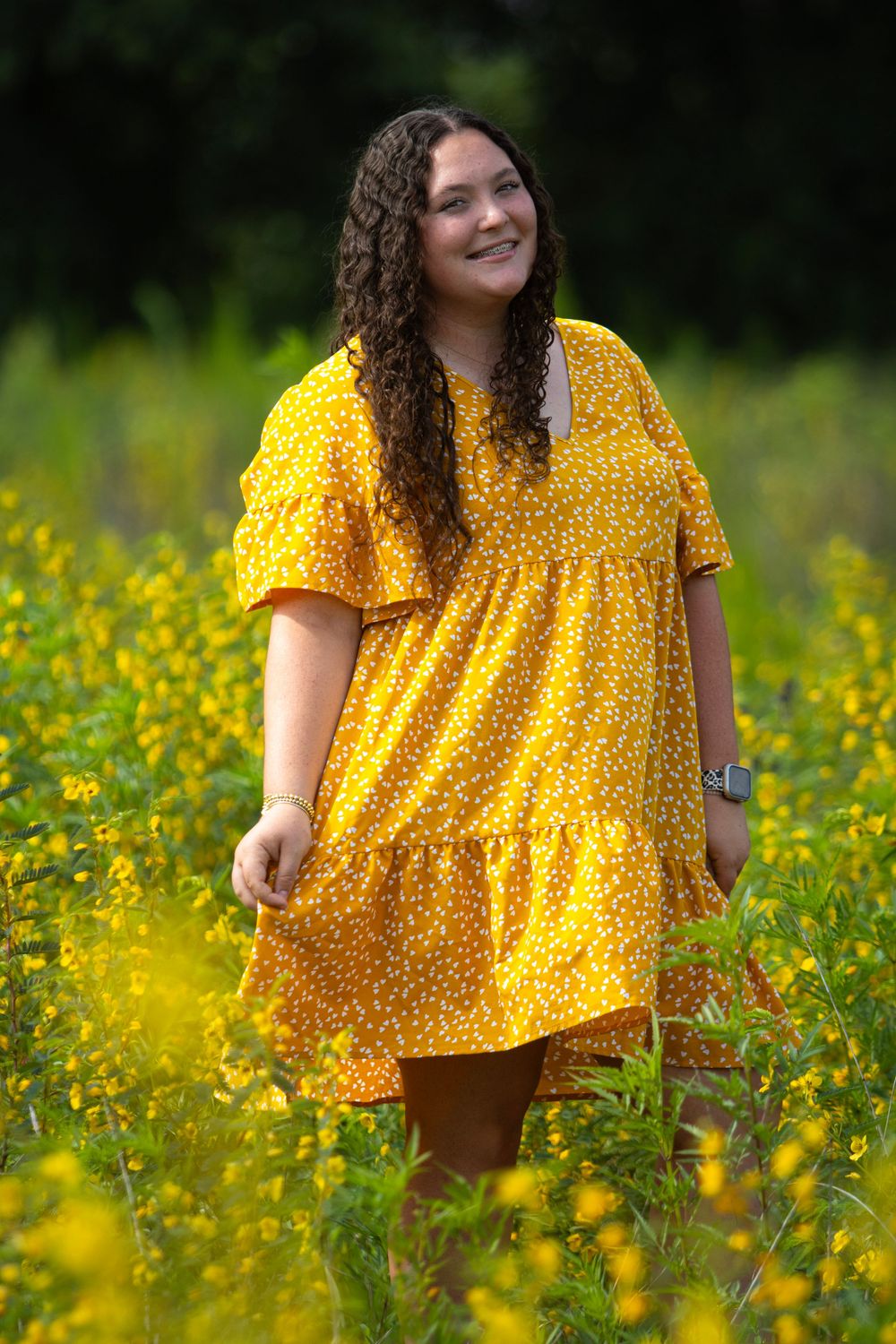 A yellow polka dot dress stands out beautifully against a field of golden wildflowers on a sunny day.