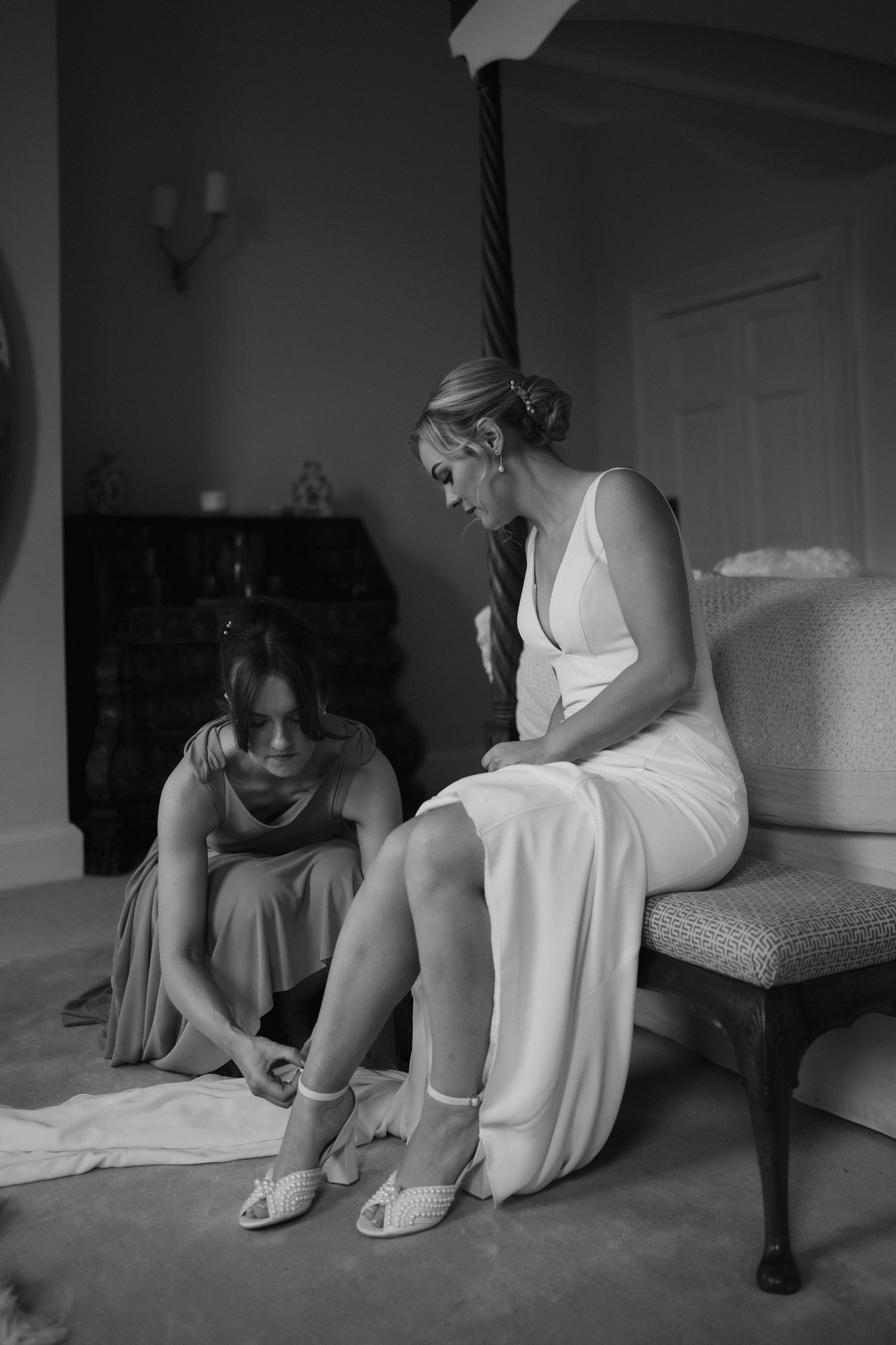 bridesmaid helping bride with shoes at Iscoyd park
