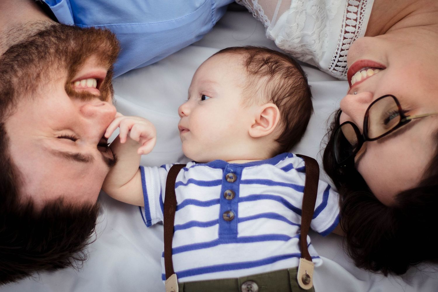 Family with newborn laughing in the grass together in Palm Bay