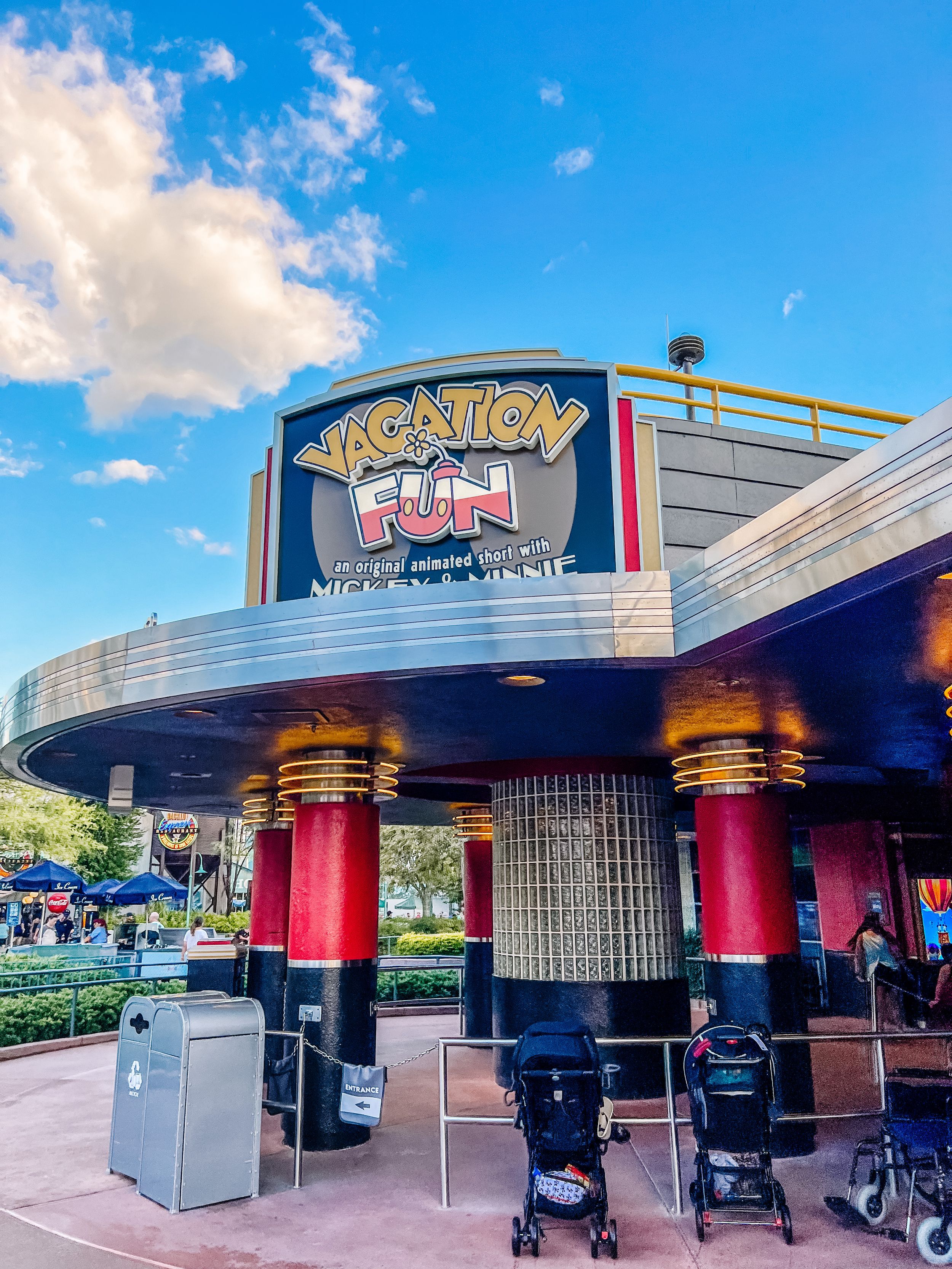 Modern red and black theater entrance with curved architectural features and columns at Disney World's Creation Shop.