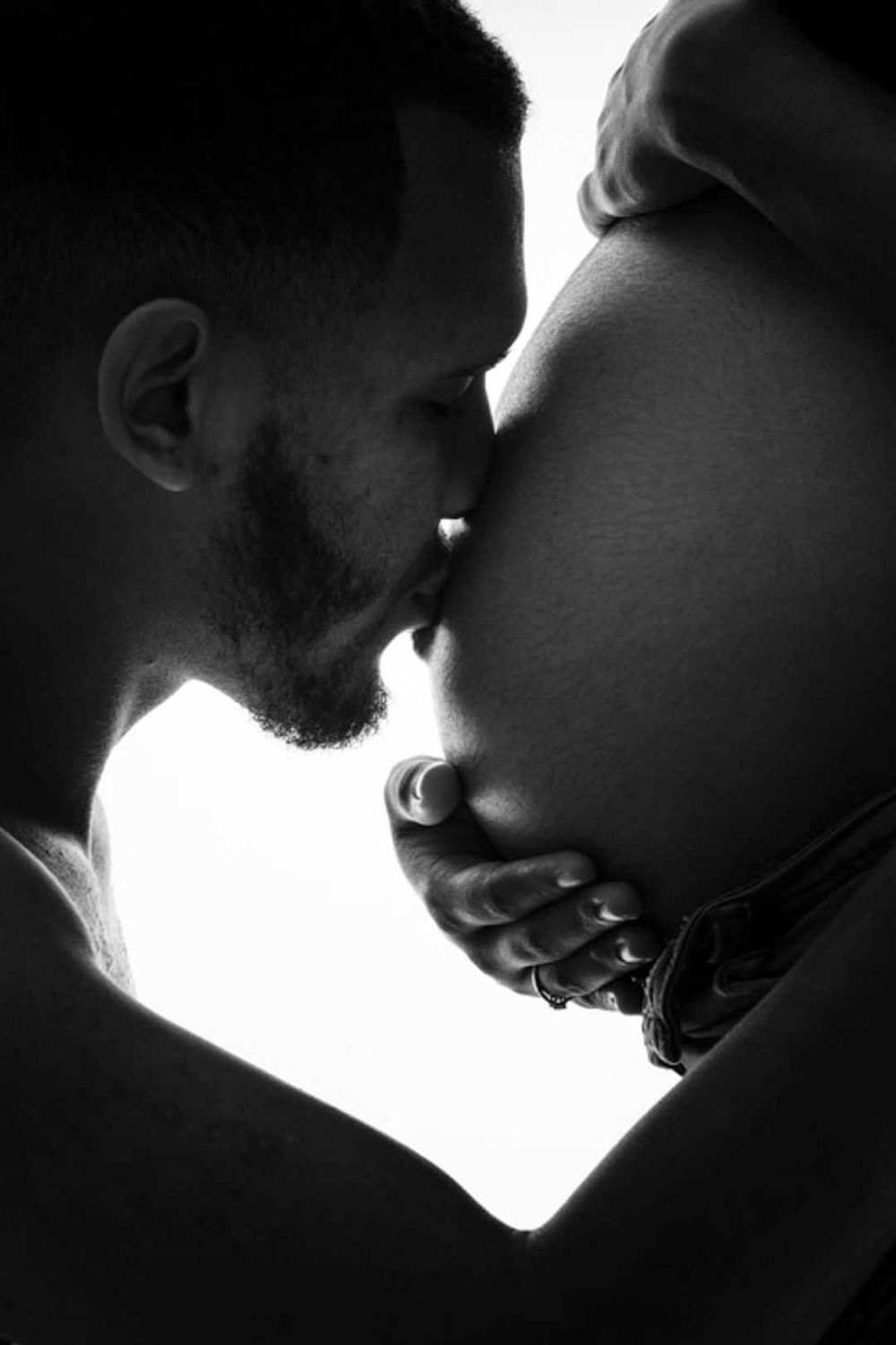 A black and white intimate silhouette of a tender kiss captures a gentle romantic moment.