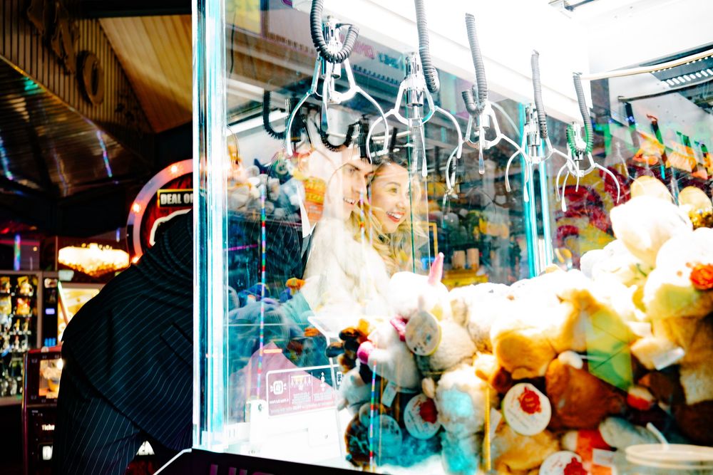 Bride and groom looking through grab them game (grabber) window in Weymouth during their New Year’s Eve wedding