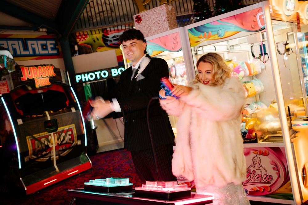 Bride and groom shooting with colourful arcade handguns in Weymouth during their New Year’s Eve wedding