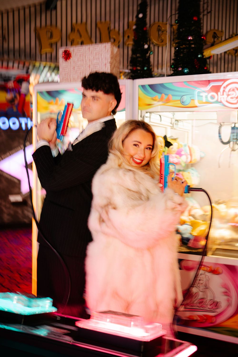 Bride and groom planned posing with colourful arcade handguns in Weymouth during their New Year’s Eve wedding