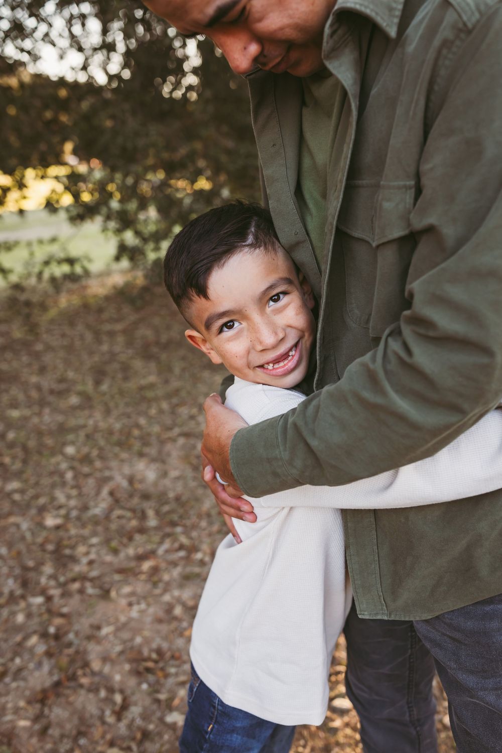 A candid sequence of playful interaction between a parent and child outdoors among fallen autumn leaves.