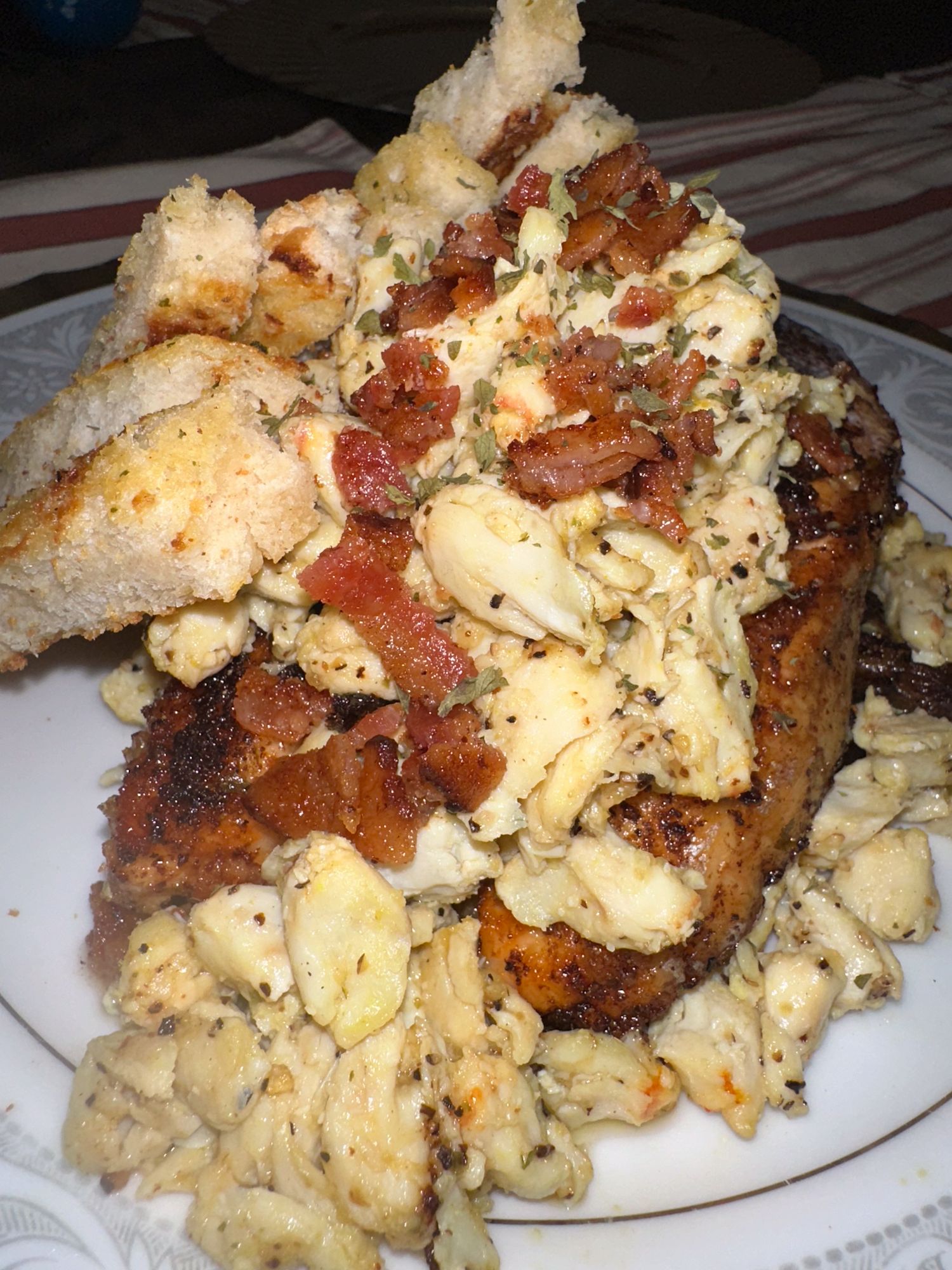Grilled chicken topped with crispy bacon and melted cheese served with a side of seasoned potatoes.
