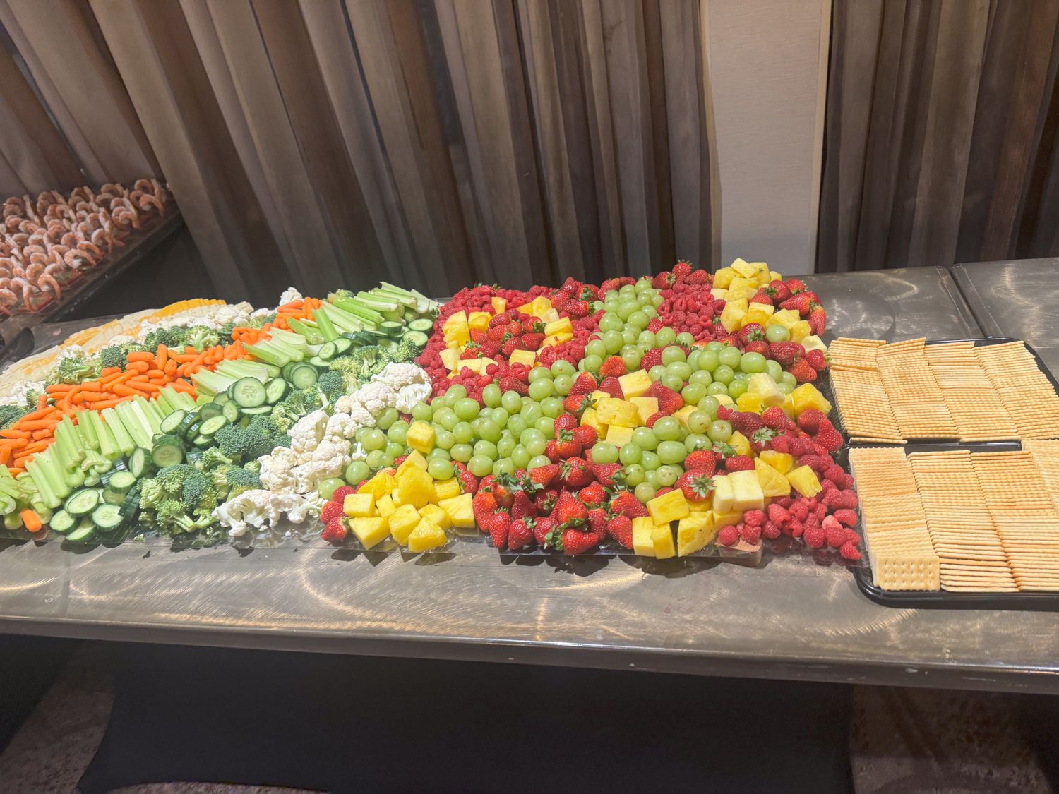 Colorful display of fresh cut vegetables arranged in rows on a buffet table.