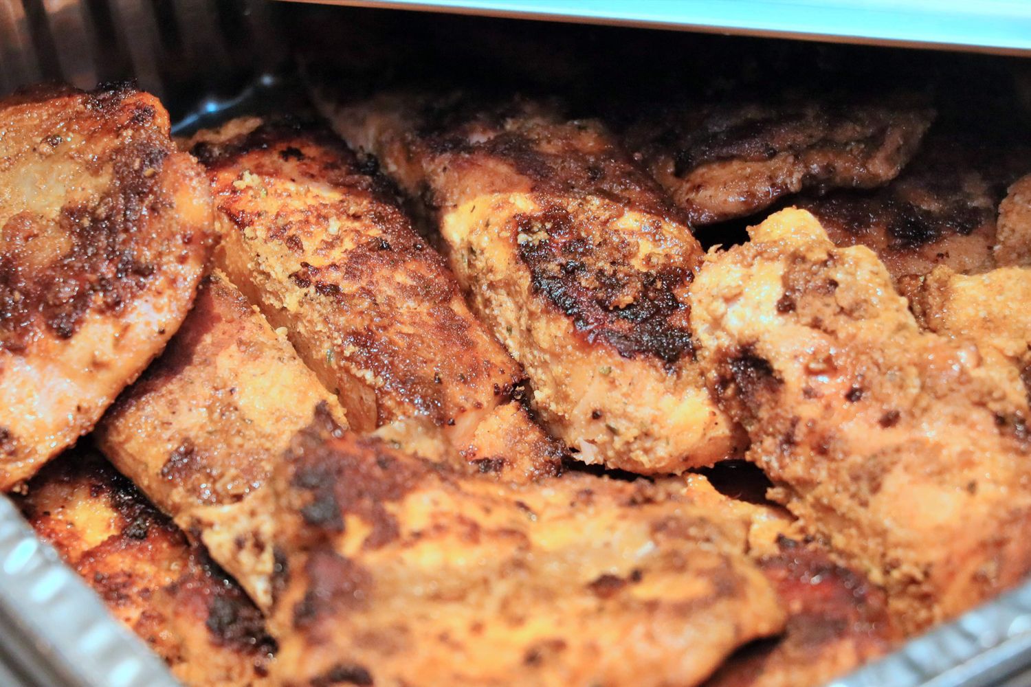 Close-up of grilled or roasted meat with a caramelized, crispy exterior.