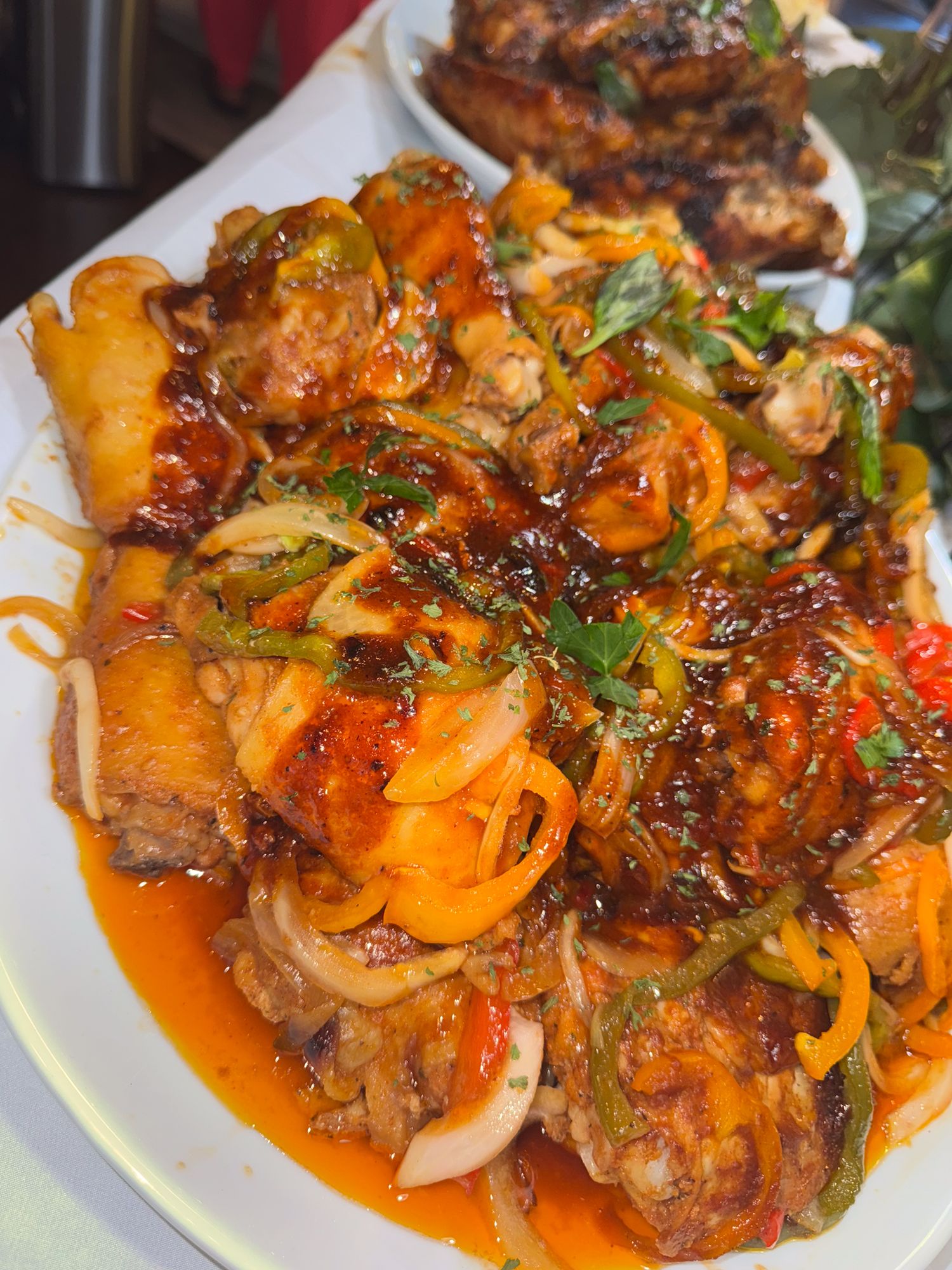 Spicy orange chicken stir fry with colorful peppers and onions served on a white plate.