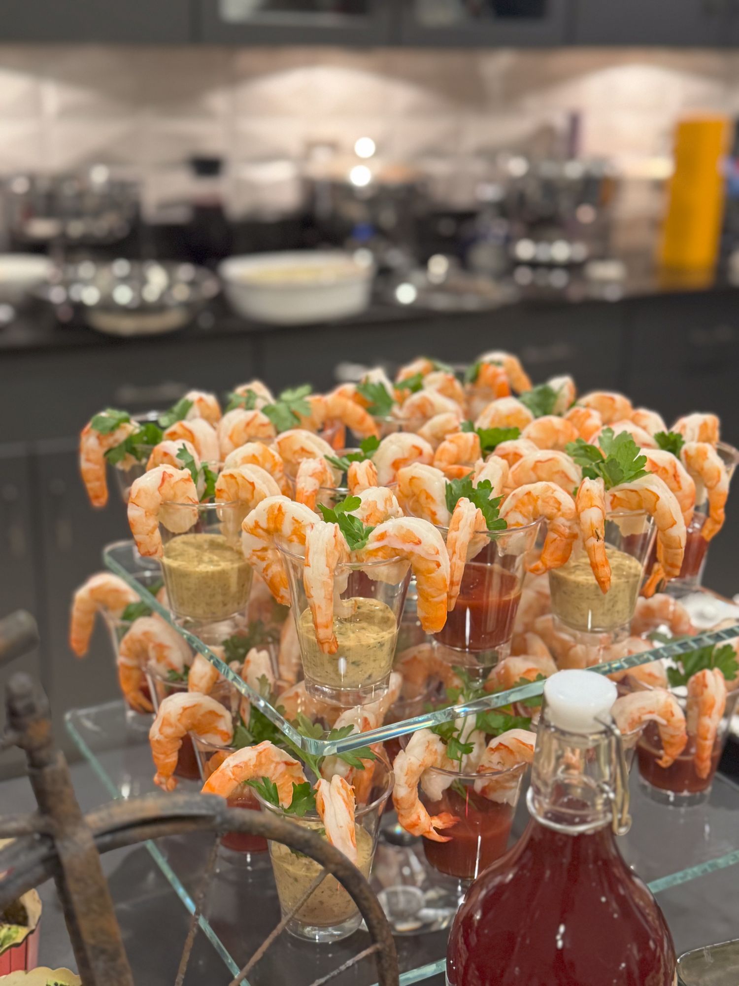 Elegant cocktail shrimp appetizers arranged in glass cups with sauce and garnish.