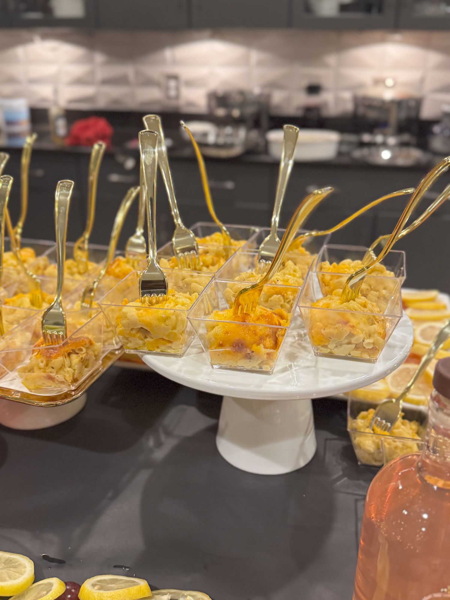 Rows of appetizer plates filled with shredded cheddar cheese and garnishes arranged on a dark surface.