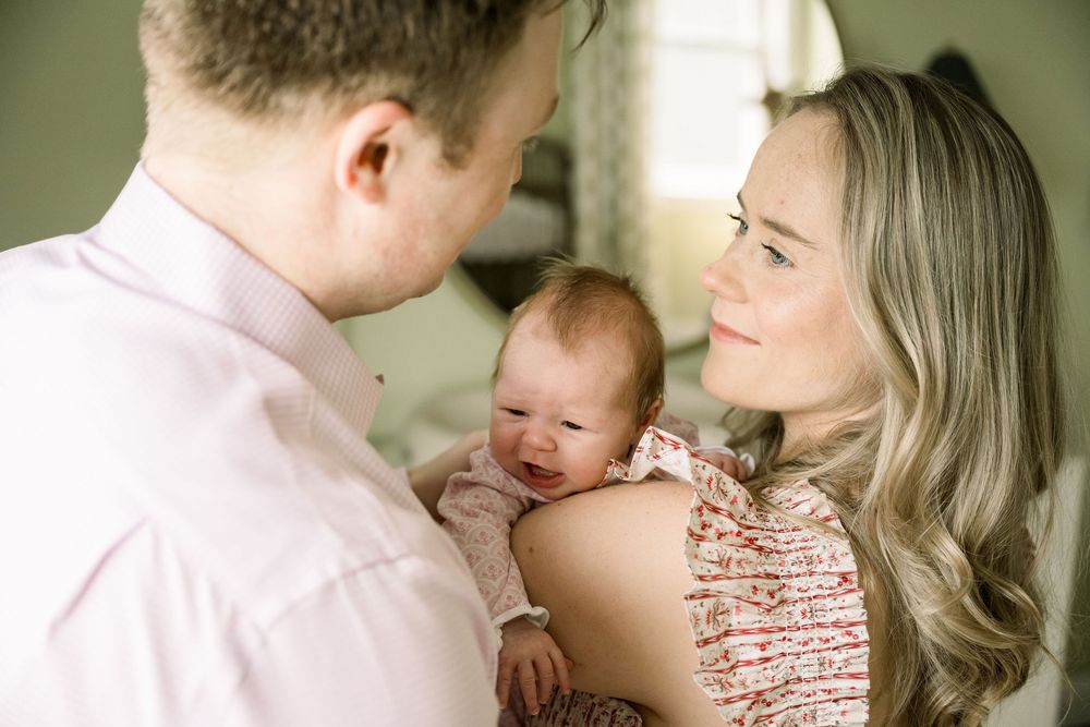 A loving family moment is captured in a series of tender black and white photographs with a baby.