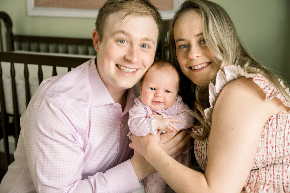 A collection of candid family photos showing tender moments between parents and baby in matching pink outfits.
