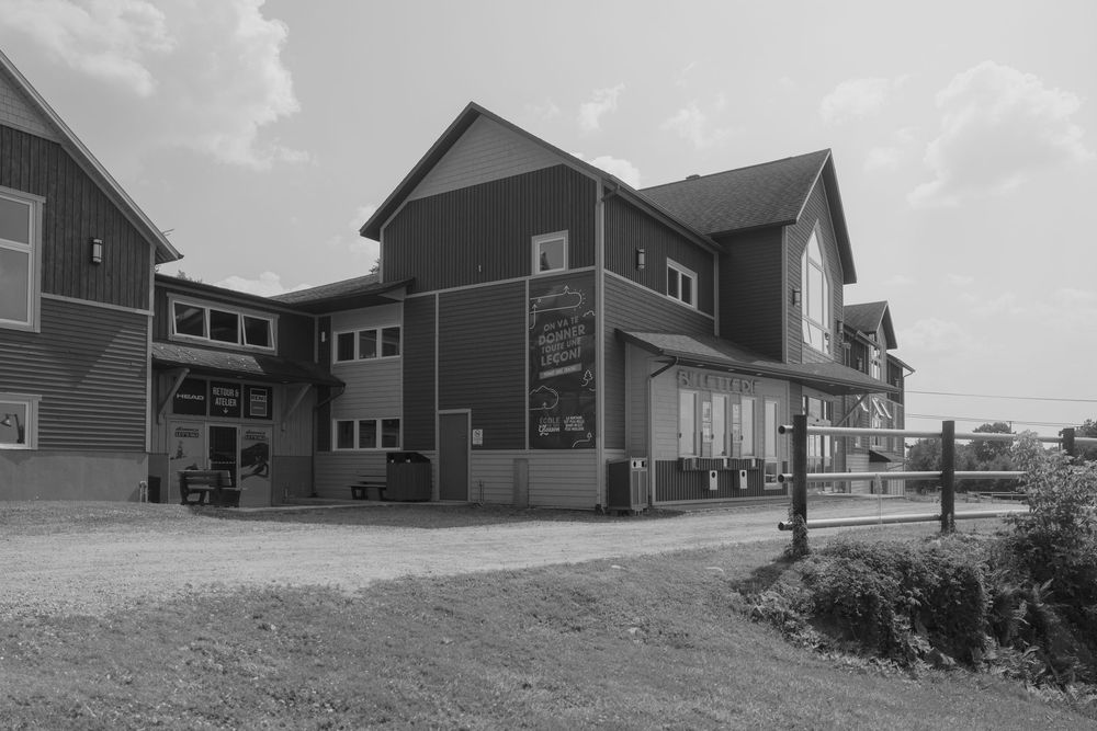 Modern rustic event venue exterior with multiple connected buildings and landscaping.