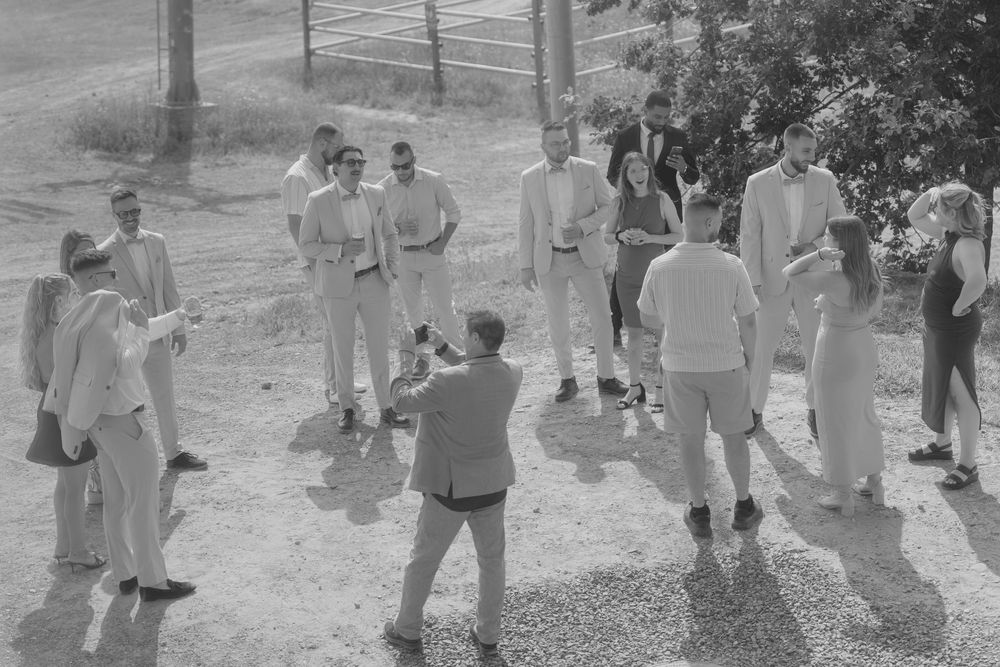 Wedding guests mingling outdoors during a casual reception gathering.