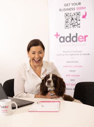 A professional workspace featuring a desk with a laptop, business cards, and a dog resting nearby.