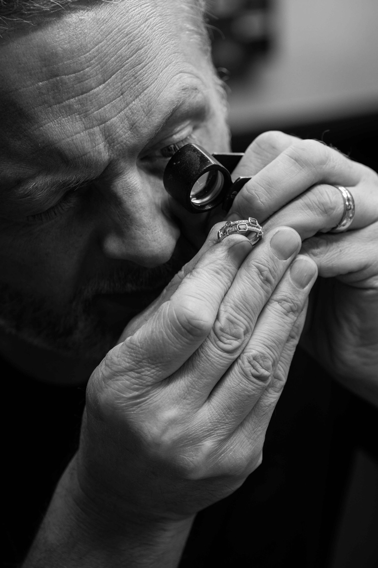 Black and white close-up sequence showing hands rolling a cigarette with tobacco and paper in five steps.