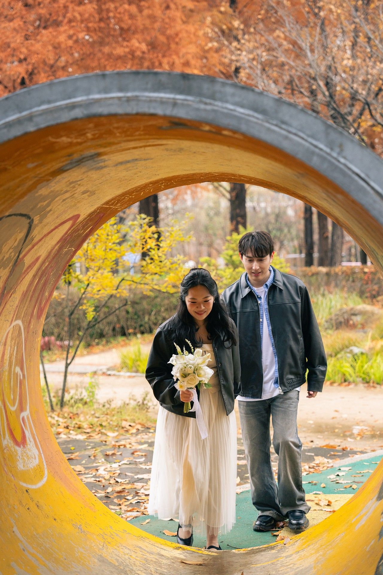 Creative wedding photo sequence showing couple framed through yellow playground tunnel in autumn park setting.