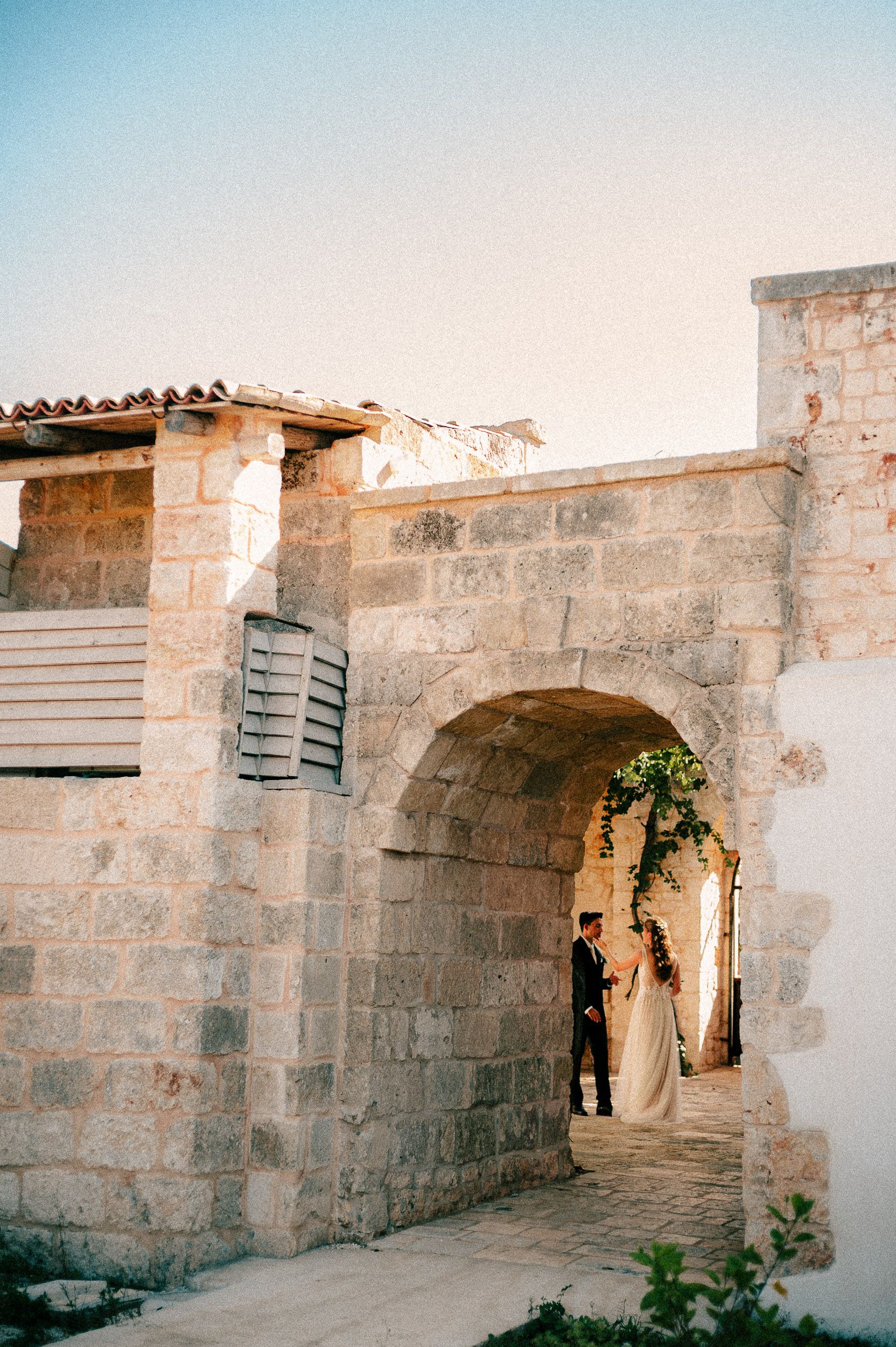 Ancient stone archways and corridors form a historic passageway in a Mediterranean building.