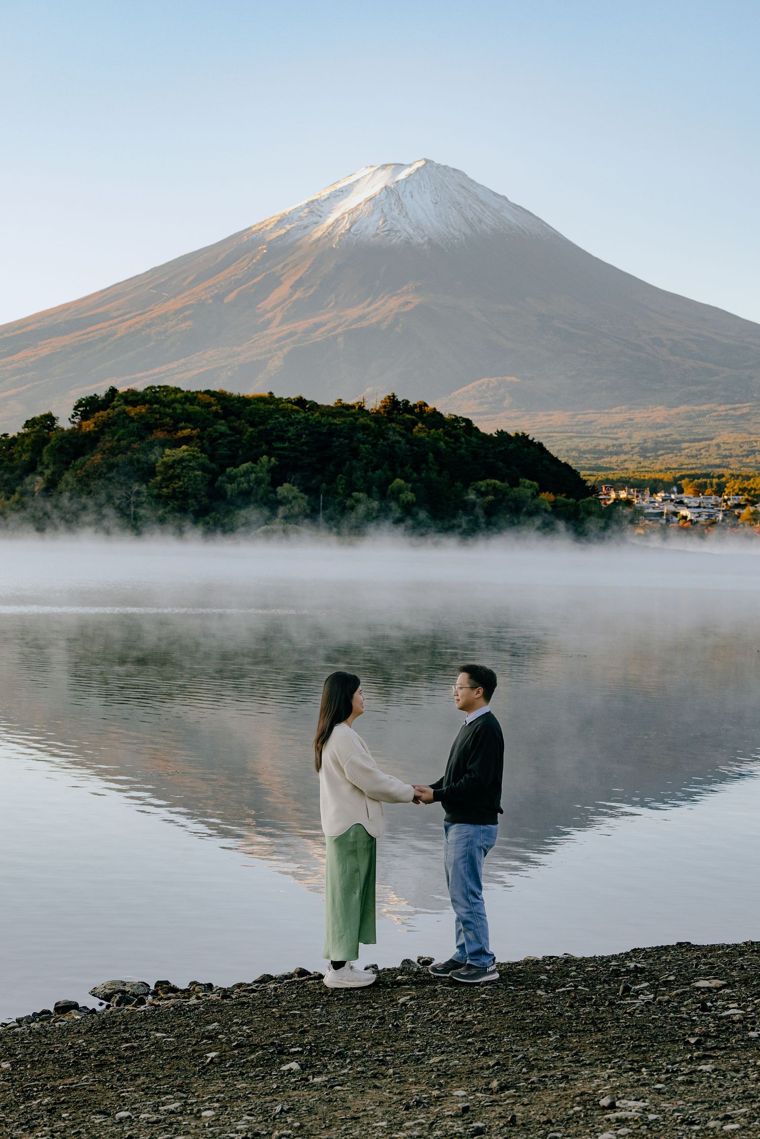 Scenic panoramic sequence of a couple proposing at misty Lake Kawaguchiko with Mount Fuji in the background at sunrise.