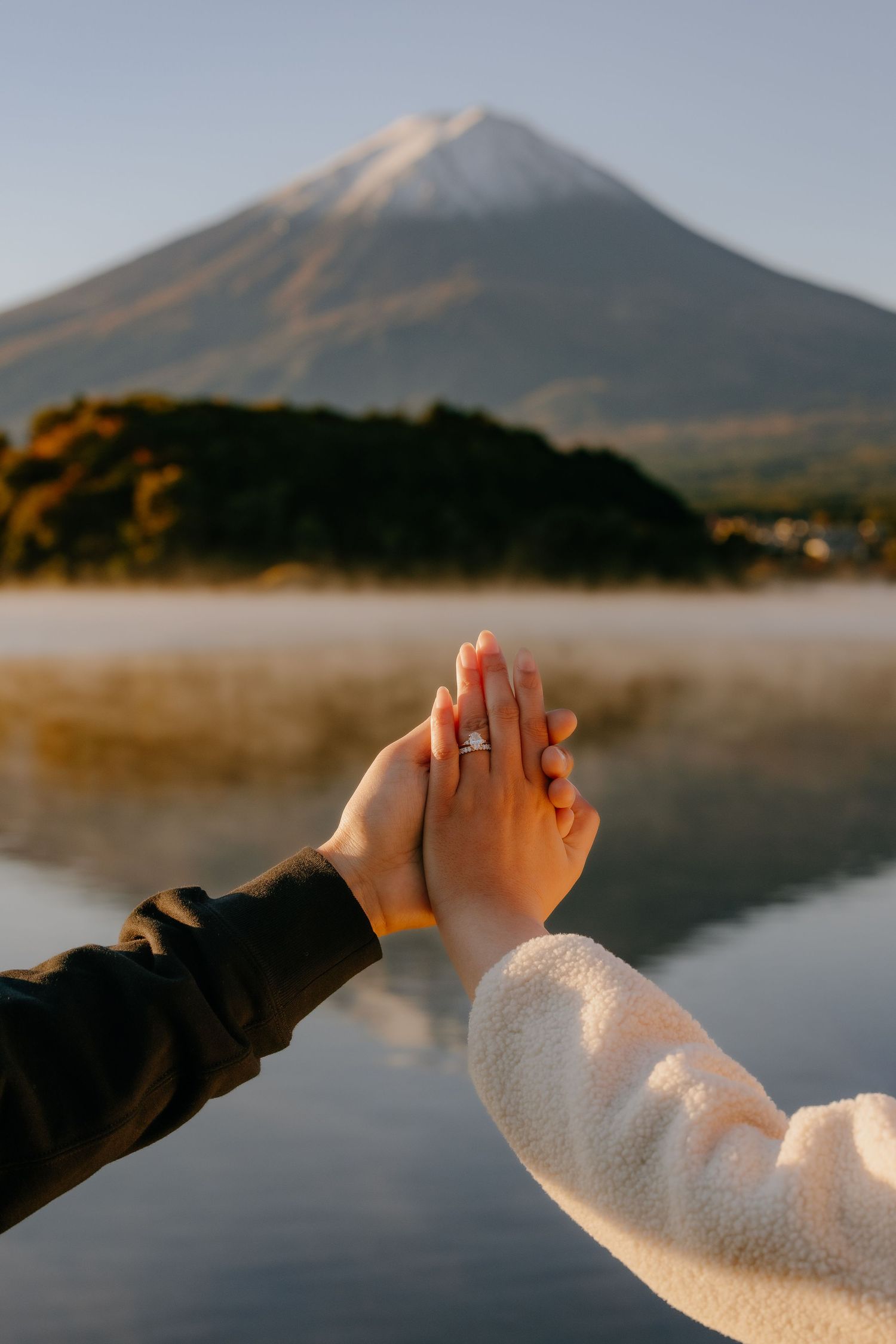 A series of hands reaching towards a misty mountain lake at sunrise creates a peaceful panoramic sequence.