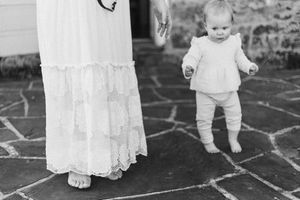 A series of black and white photographs showing a baby's first steps on a stone patio.