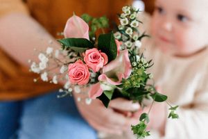 Delicate pink roses and white baby's breath flowers arranged in small glass vases for a romantic wedding centerpiece.