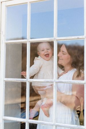 A series of window panes showing a tender moment of laughter and joy between parent and baby.