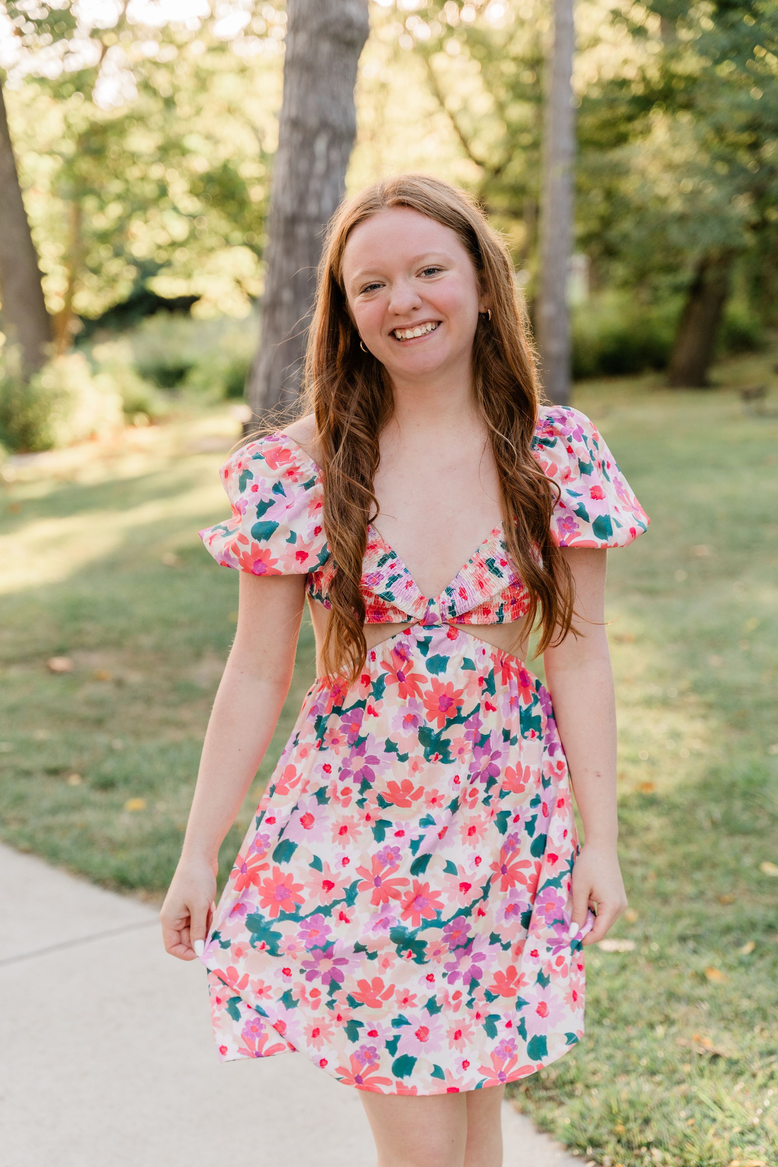 A series of portraits in a floral pink dress posing playfully in a sunny outdoor garden setting.