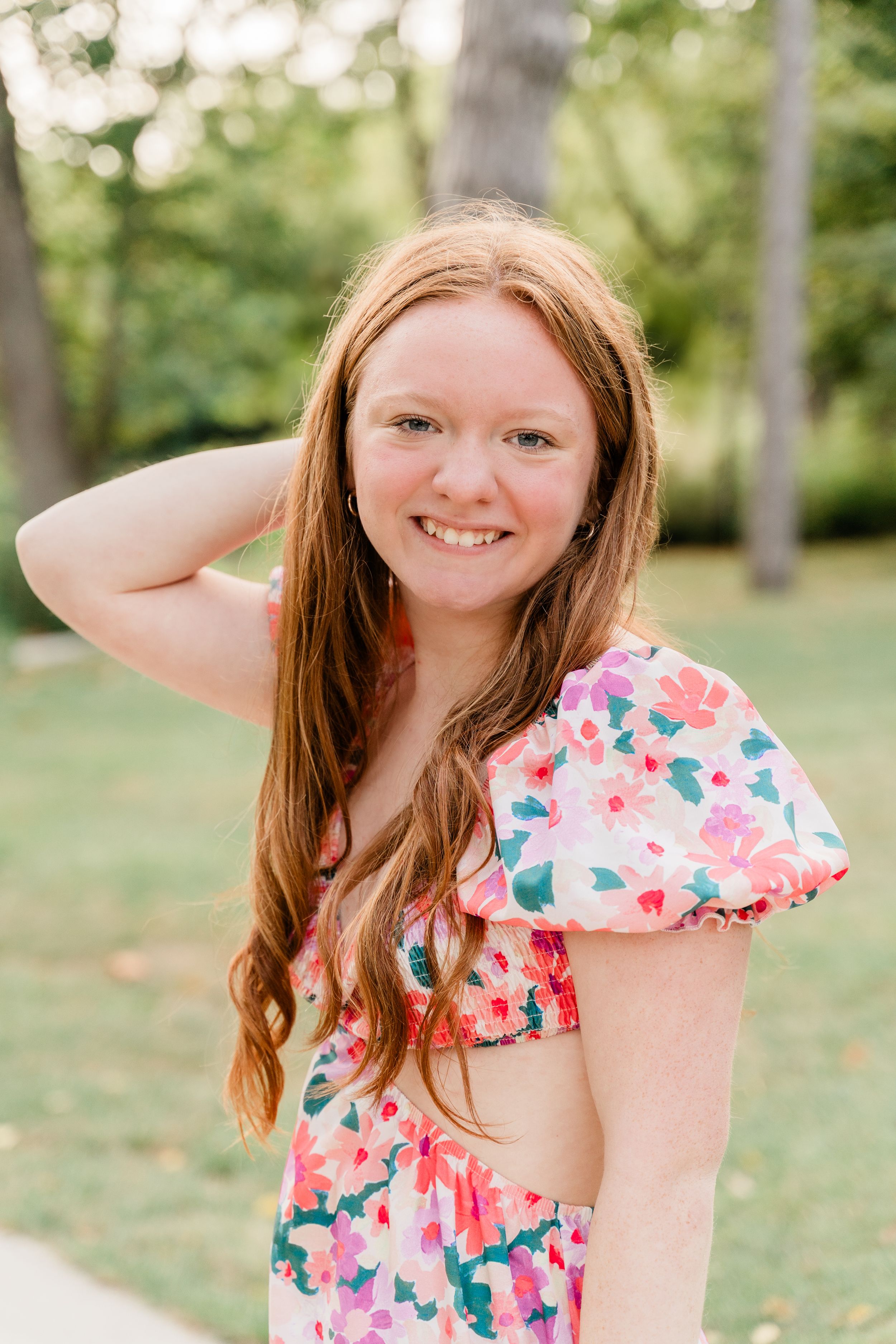 Candid shots showing joyful movement and laughter while wearing a pink floral summer dress outdoors.