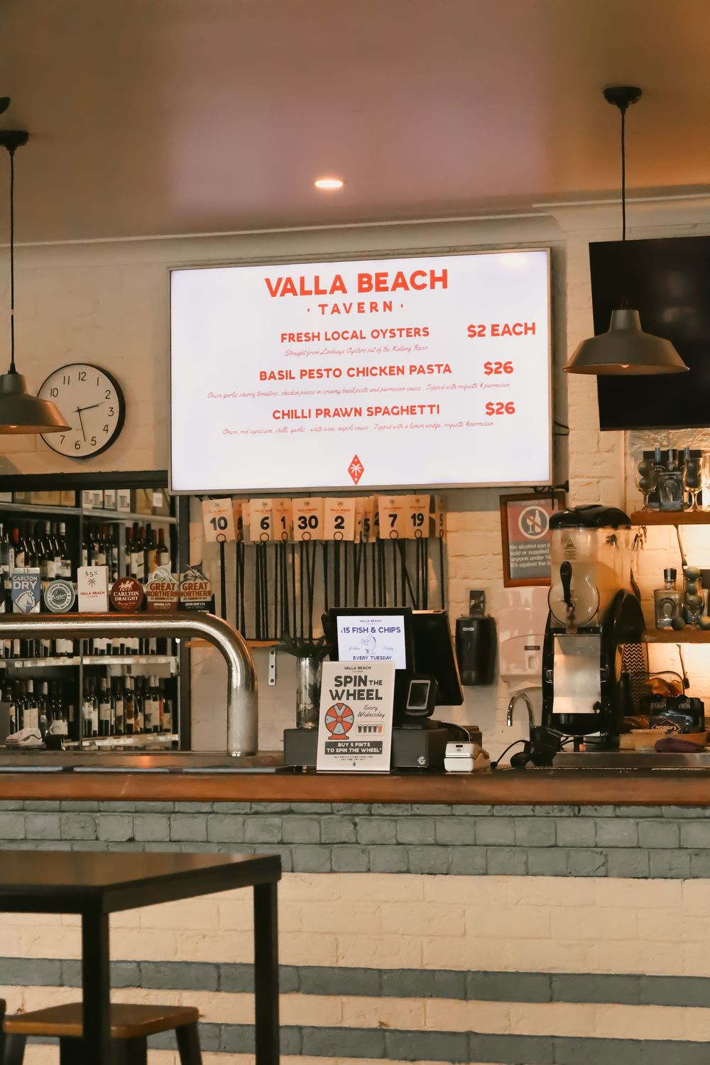 Interior view of Valla Beach Tavern showing menu boards and counter service area with ambient lighting.