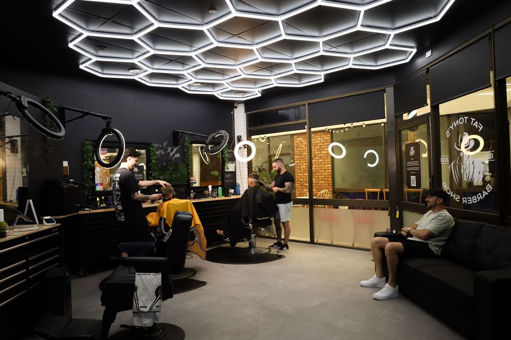 Modern office space with hexagonal ceiling lights and sleek black and gold interior design elements.