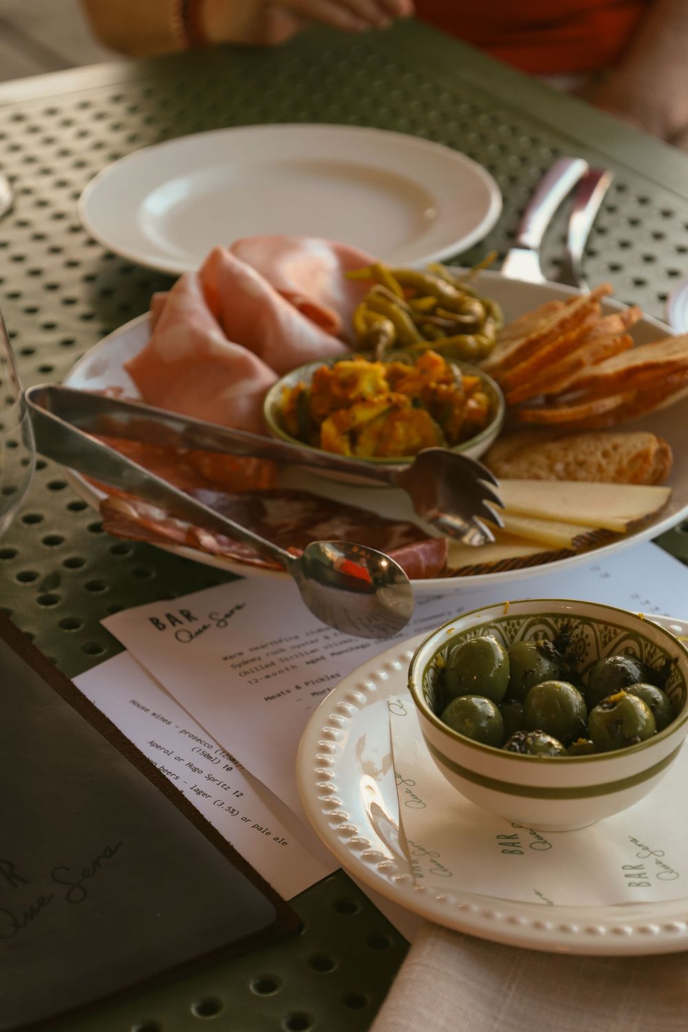 A series of restaurant dishes and appetizers on white plates arranged in a sequence on a table setting.