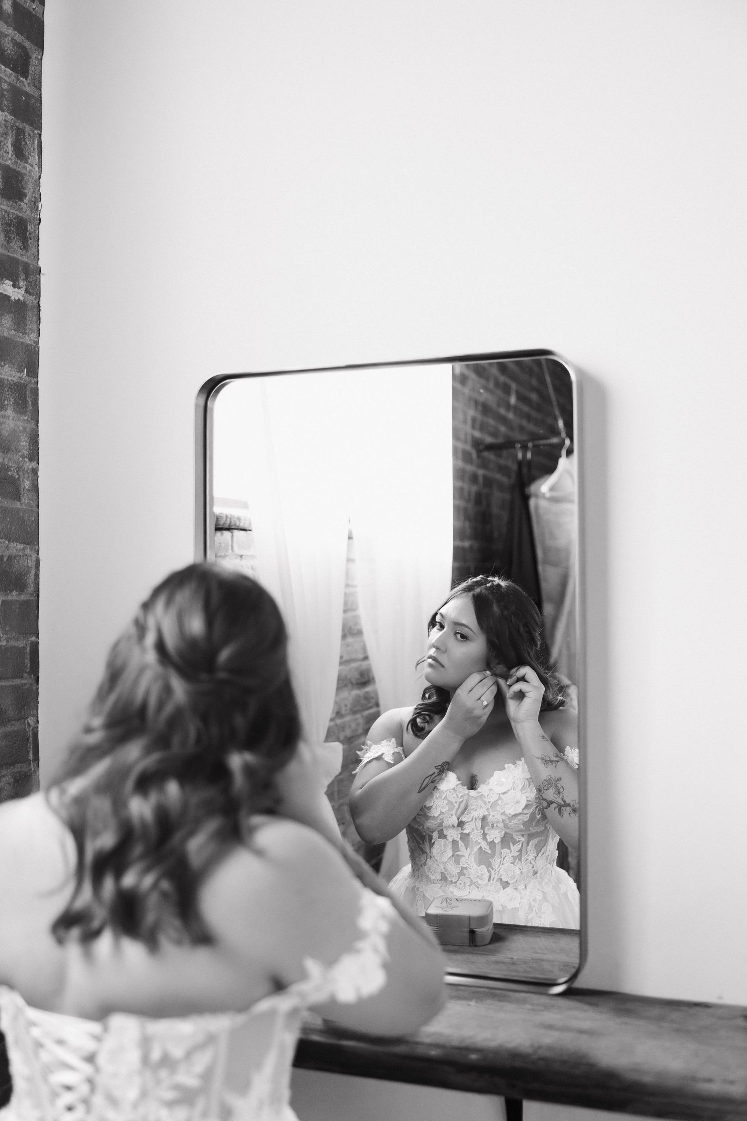 A series of black and white photos showing someone applying makeup in a mirror reflection.