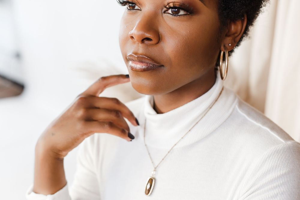 A series of four headshots showing someone wearing a white turtleneck sweater against a light background.