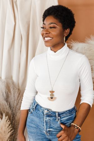 Four fashion portraits showing a casual outfit with white turtleneck sweater, blue jeans and delicate jewelry.