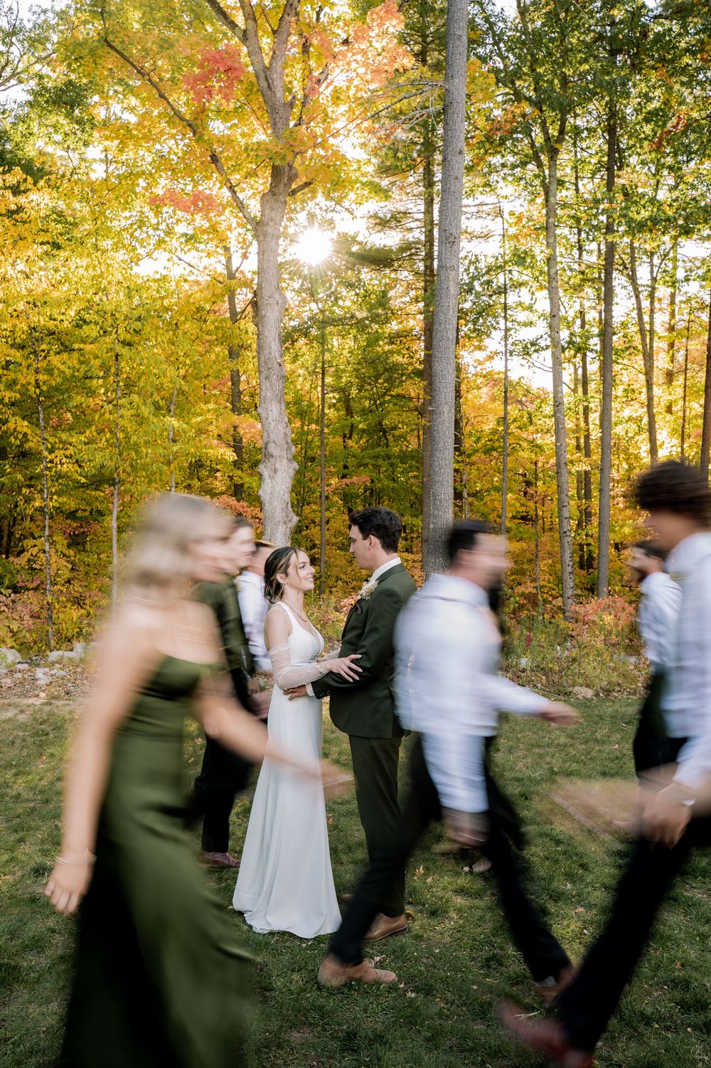 Motion blur sequence shows wedding party dancing and moving through autumn forest at golden hour.