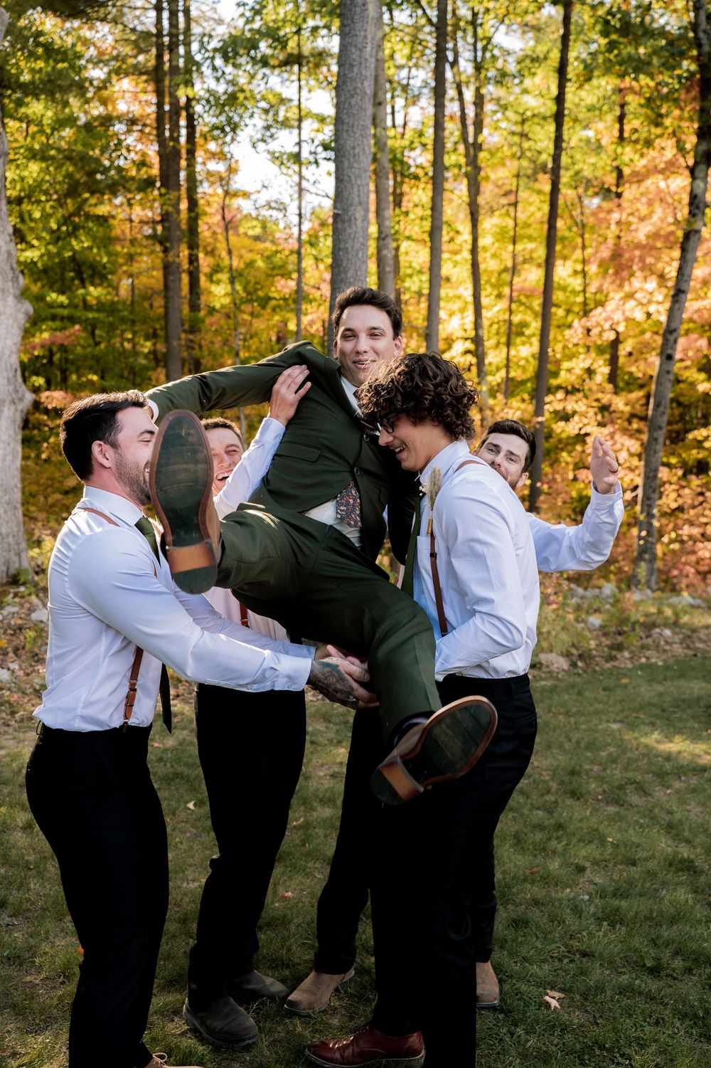 Wedding party performs choreographed dance moves in a sunlit autumn forest setting.