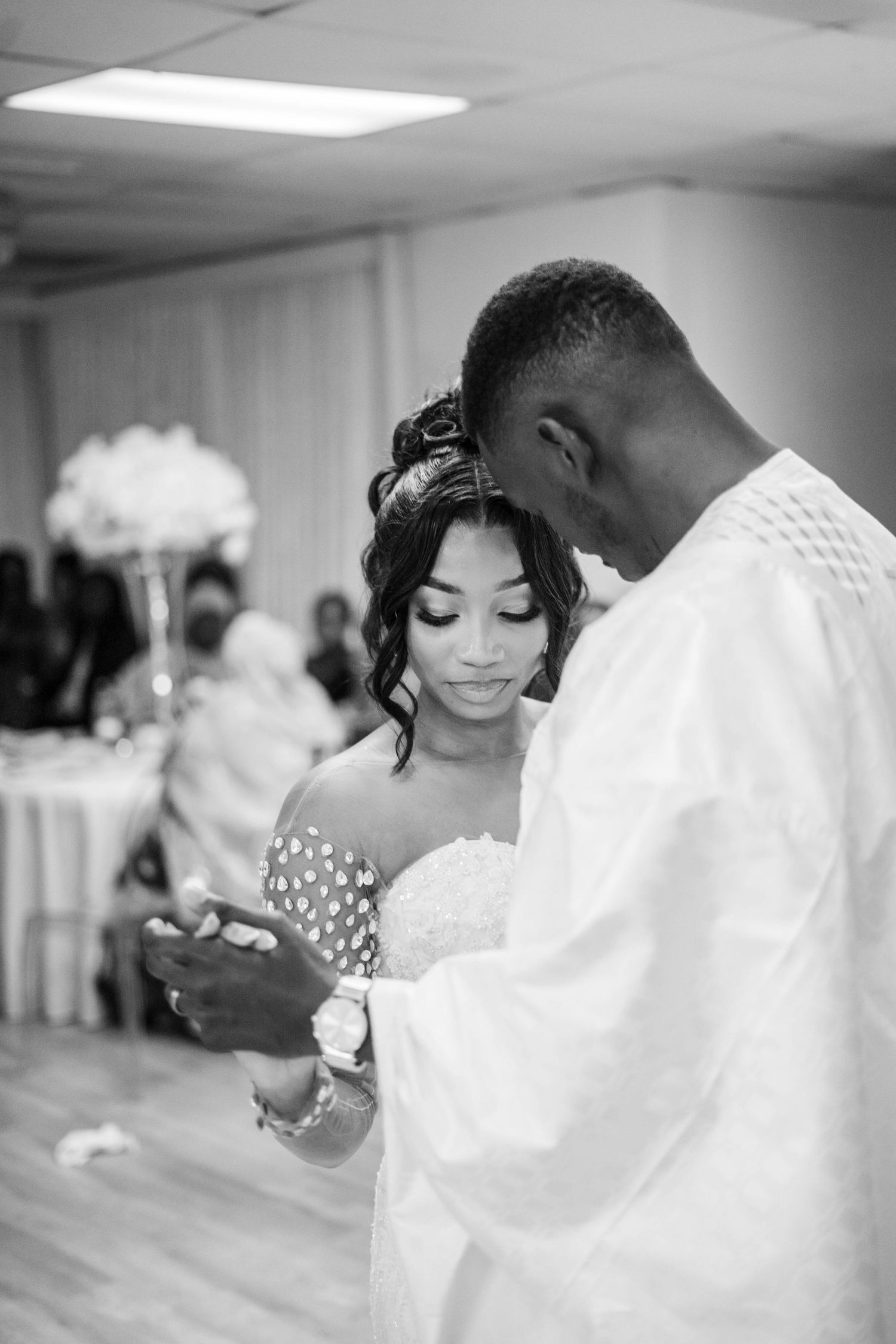 Black and white photo of bride and groom sharing intimate first dance moment at wedding reception.