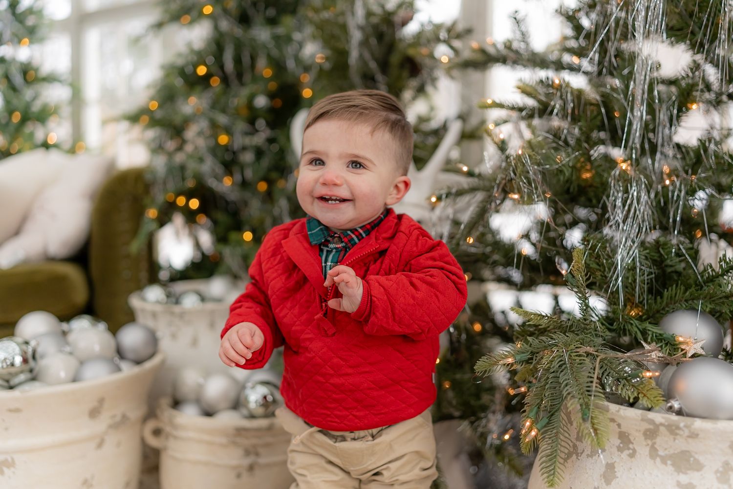 Festive holiday scene with decorated Christmas trees and winter greenery.