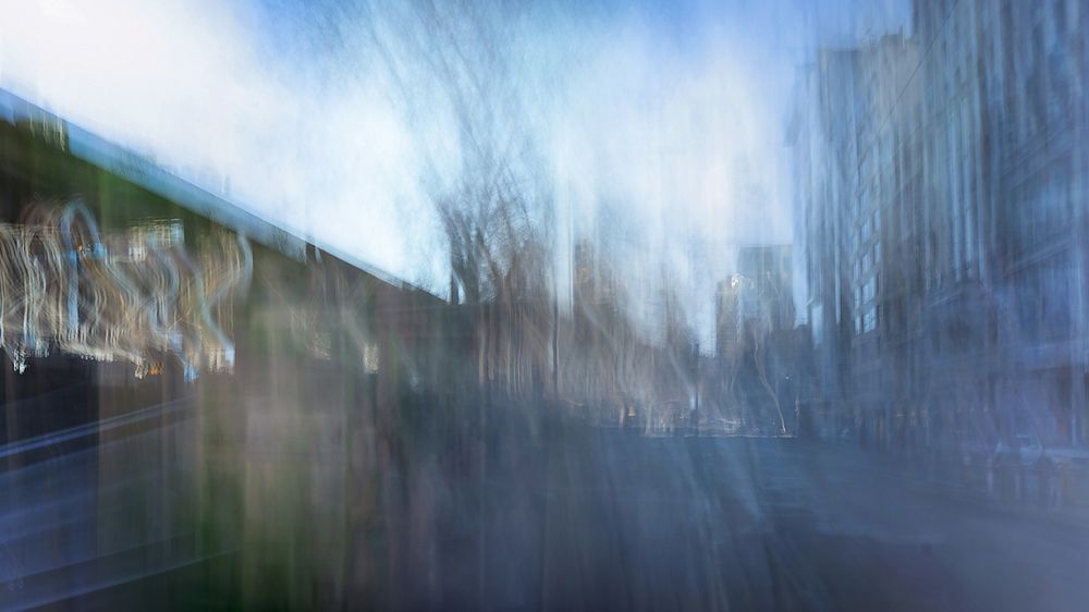 Abstract urban landscape with motion blur effect creating a dreamy blue and gray cityscape reflection.